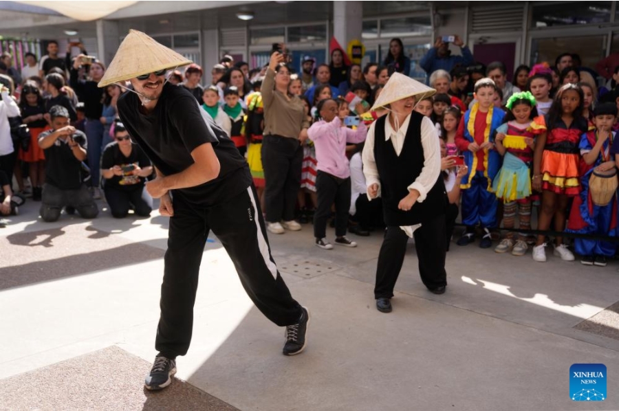 Imagen del 26 de septiembre de 2024 de maestros realizando una presentación durante el 20° aniversario de la denominación como República Popular China de una escuela primaria estatal en el barrio Casavalle, en Montevideo, capital de Uruguay. Con coloridas danzas y presentaciones musicales, cientos de ni?os uruguayos celebraron el 20° aniversario de la denominación como República Popular China de una escuela primaria estatal de Montevideo, que tiene el apoyo de la Embajada china. (Xinhua/Nicolás Celaya)