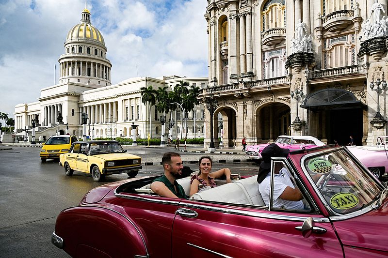 Turistas viajan en un automóvil clásico en La Habana, Cuba, mientras la compa?ía eléctrica local informa que se ha restablecido la electricidad en la mitad de la ciudad el 21 de octubre de 2024. (Foto: VCG)